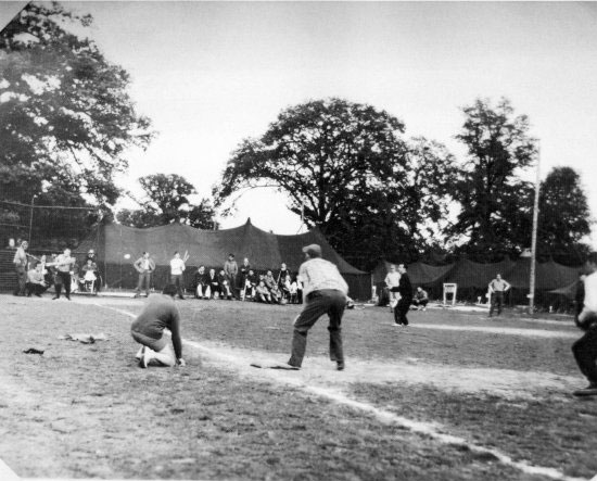 Hospital personnel engage in a friendly game of baseball during a quiet period in activities.