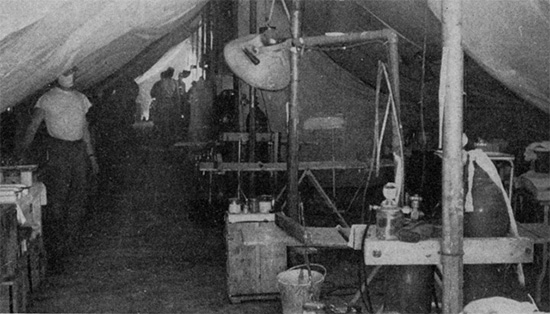 General view of an operating room set up under canvas in the field. The white cotton liners for the tents can be clearly seen. 