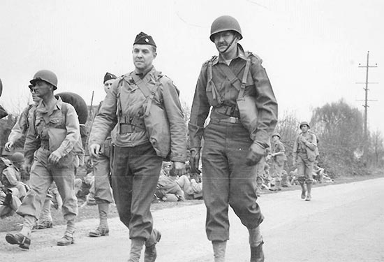 Major Quintus Nicola (R, with helmet liner) during a road march, while training at Camp White, Medford, Oregon.