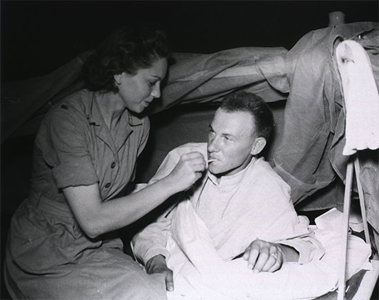 Nurse taking the temperature of a patient, 95th Evacuation Hospital.