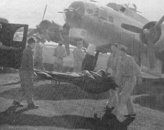 Wounded servicemen are transferred from Air Force transport to Ambulances destined for the 26th General Hospital.