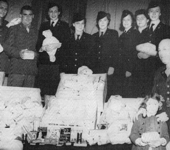 Hospital staff pose proudly for a photograph with gifts and other goodies received from friends and family during their first Christmas overseas. 