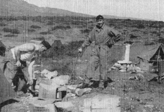 Two unidentified men of the unit prepare their shelter tents and surrounding area in North Africa. 