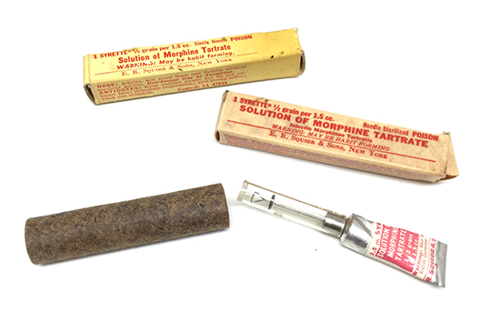 Illustration showing Item No. 9775700; Morphine Tartrate, 1 Tube with different designs of outer box. The hard fibreboard tube was used to protect the Syrette in certain types of First-Aid Kits (notably the Parachute First-Aid Packet – Item No. 9778500).