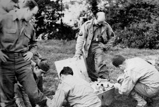 31 July 1944, Transit Area B, Utah Beach, Normandy. Hurting feet receive some treatment. 