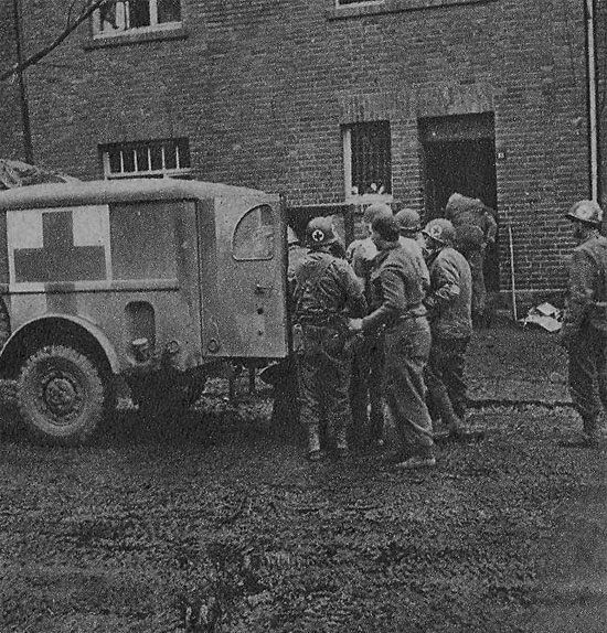 Medical personnel help patients into a 3/4-ton Ambulance for evacuation to an Army Hospital in the rear.