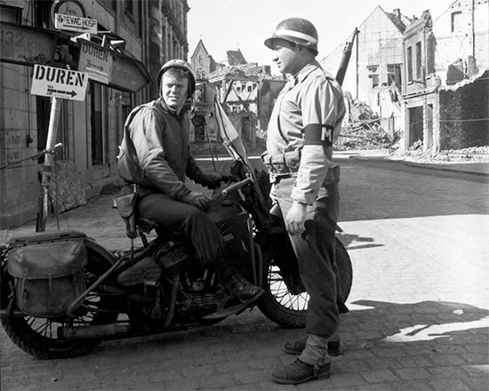 Military Police patrol, somewhere on the road to Düren, Germany. See the 5th Evac Hosp sign (top left).