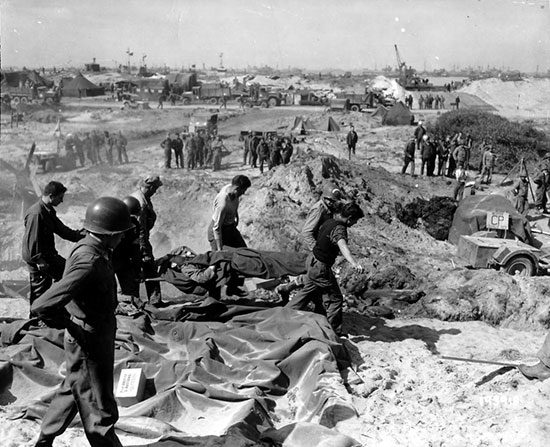 Utah Beach, June 1944. Personnel of the 1st Engineer Special Brigade bringing in a dead soldier for temporary burial. 