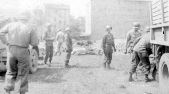 Personnel of the 603d QM GR Co loading bodies at a Collecting Point, near Eisleben, Germany, April 1945.