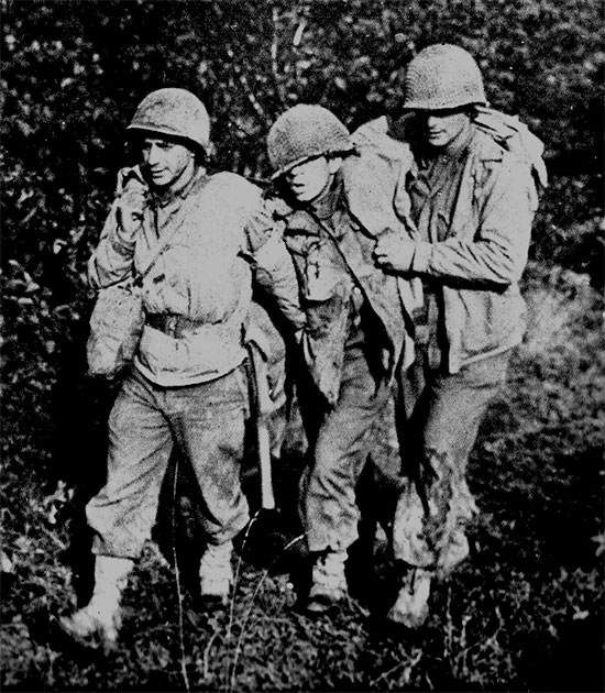 Somewhere in Alsace-Lorraine, France. A medic helps 2 wounded soldiers to an Aid Station set up in the field. 