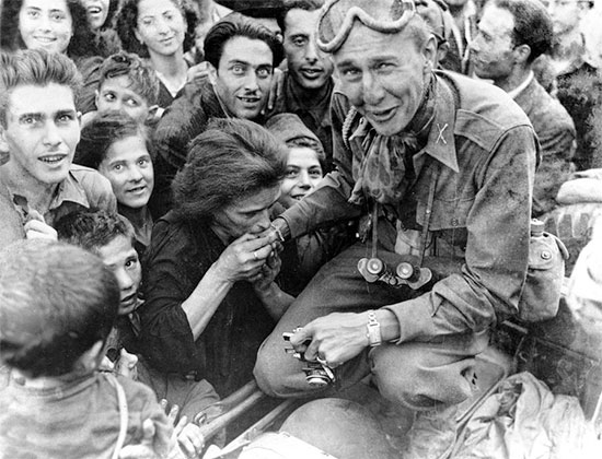 Following its liberation, the British 7th Armoured Division occupied Naples without opposition on 1 October 1943. Local women welcome and kiss one of the first GIs to enter the city. 