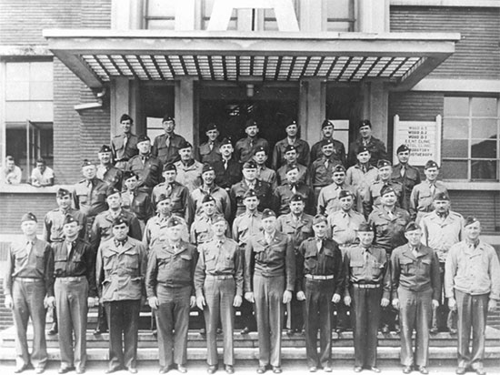 Group of Officers of the 25th General Hospital, in front of the main entrance to one of the military barracks occuped by the unit at Tongres, Belgium.