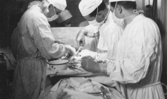 Operating Room, 25th General Hospital. From L to R: Major Daniel E. Earley and Captain George E. Schnug, assisted by a Private, in action.