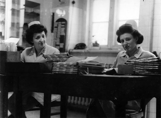 Second Lieutenant Olga A. Petza and another unidentified Nurse carry out various administrative tasks in their office at the 