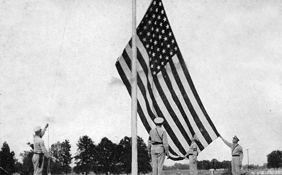 MPs hoist the "Stars and Stripes" above Camp McCain (birthplace of the 623d Medical Clearing Company) during the summer of 1942. 