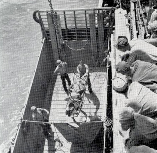 American casualty being loaded aboard a transport vessel in Leyte harbor, 20 October 1944.