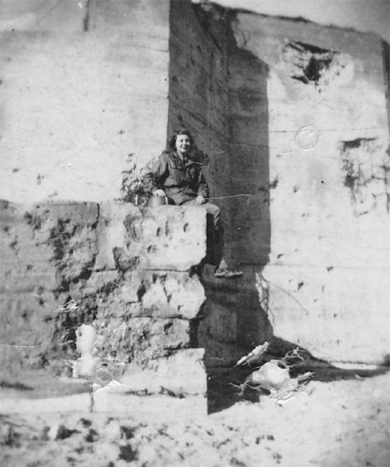 Lieutenant Jones pictured sitting on a partially-destroyed concrete bunker on Utah Beach, July 1944.